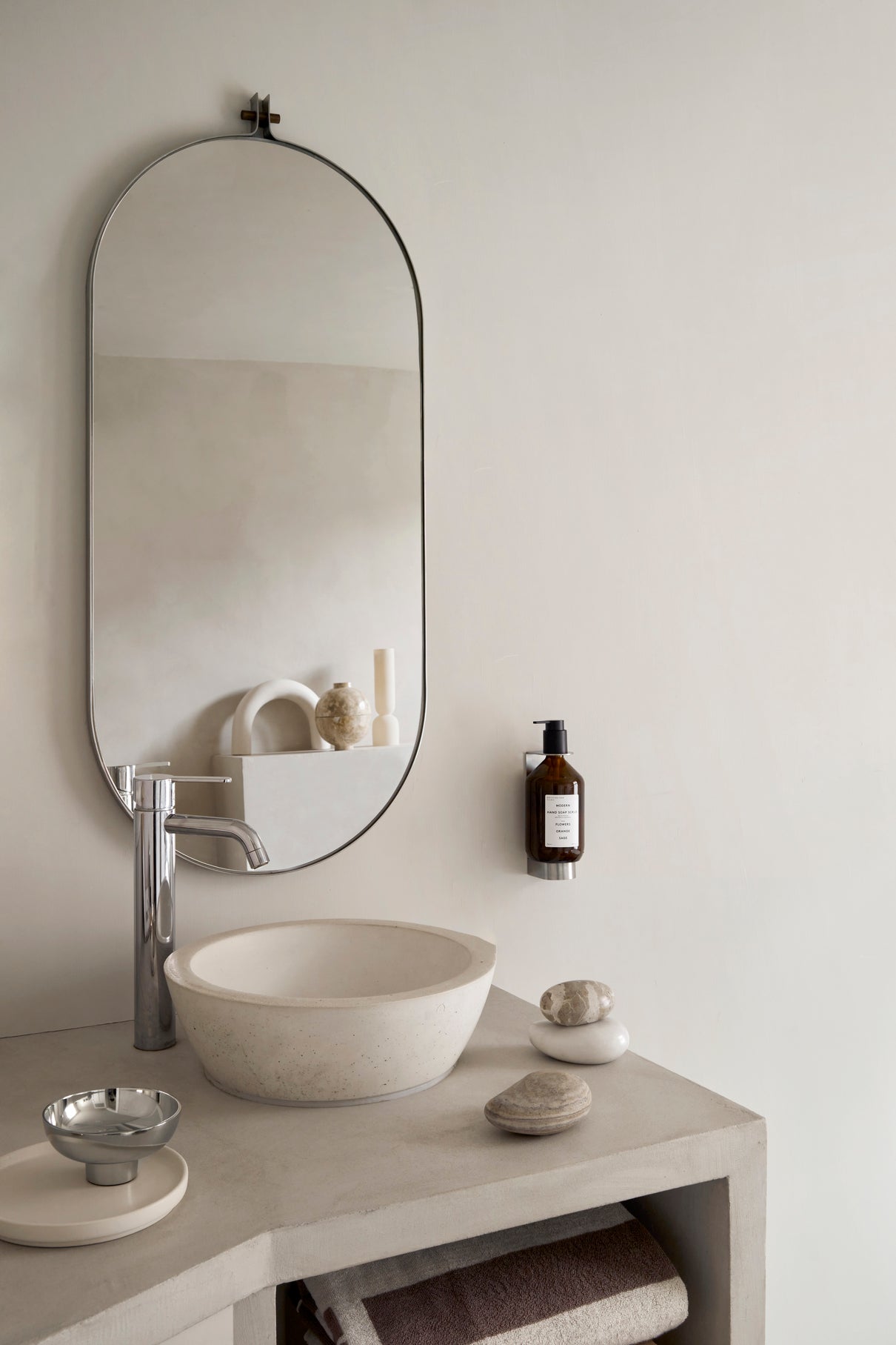 Dowel Mirror Long by Kristina Dam. Mirror in round capsule shape in a bathroom interior setting.
