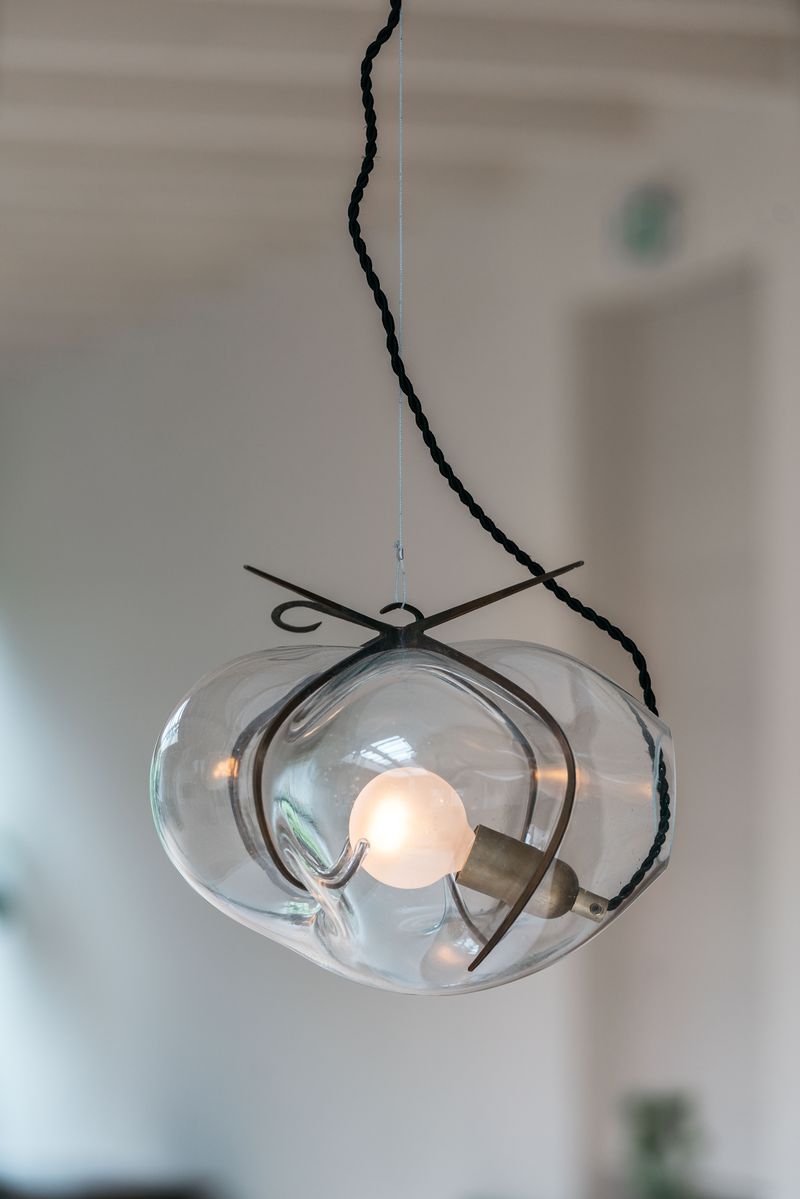 Exhale Pendant Lamp by WDSTCK. A hanging glass bubble with metal frame lights on.