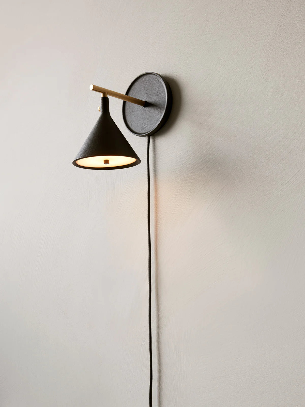 Menu Cast Sconce Wall Lamp Diffuser, dimmer with light turned on.