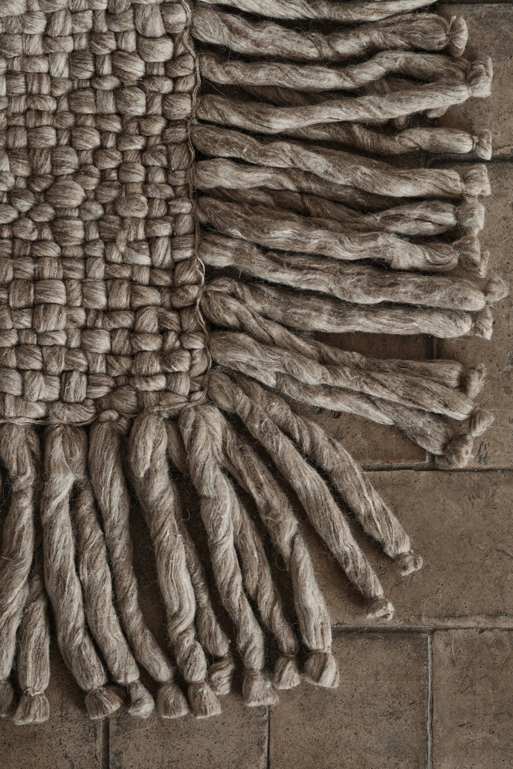 Details of beige handwoven rug with tassels