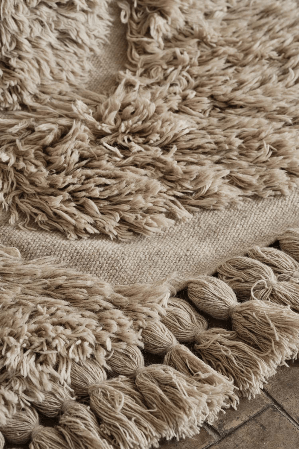 detail photo of neutral handwoven rug with big tassels