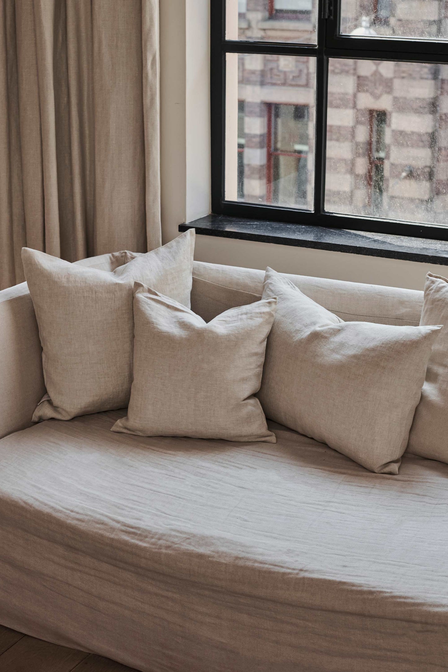 Natural Linen Cushions by Timeless Linen set on couch in a light and neutral interior at Enter The Loft.