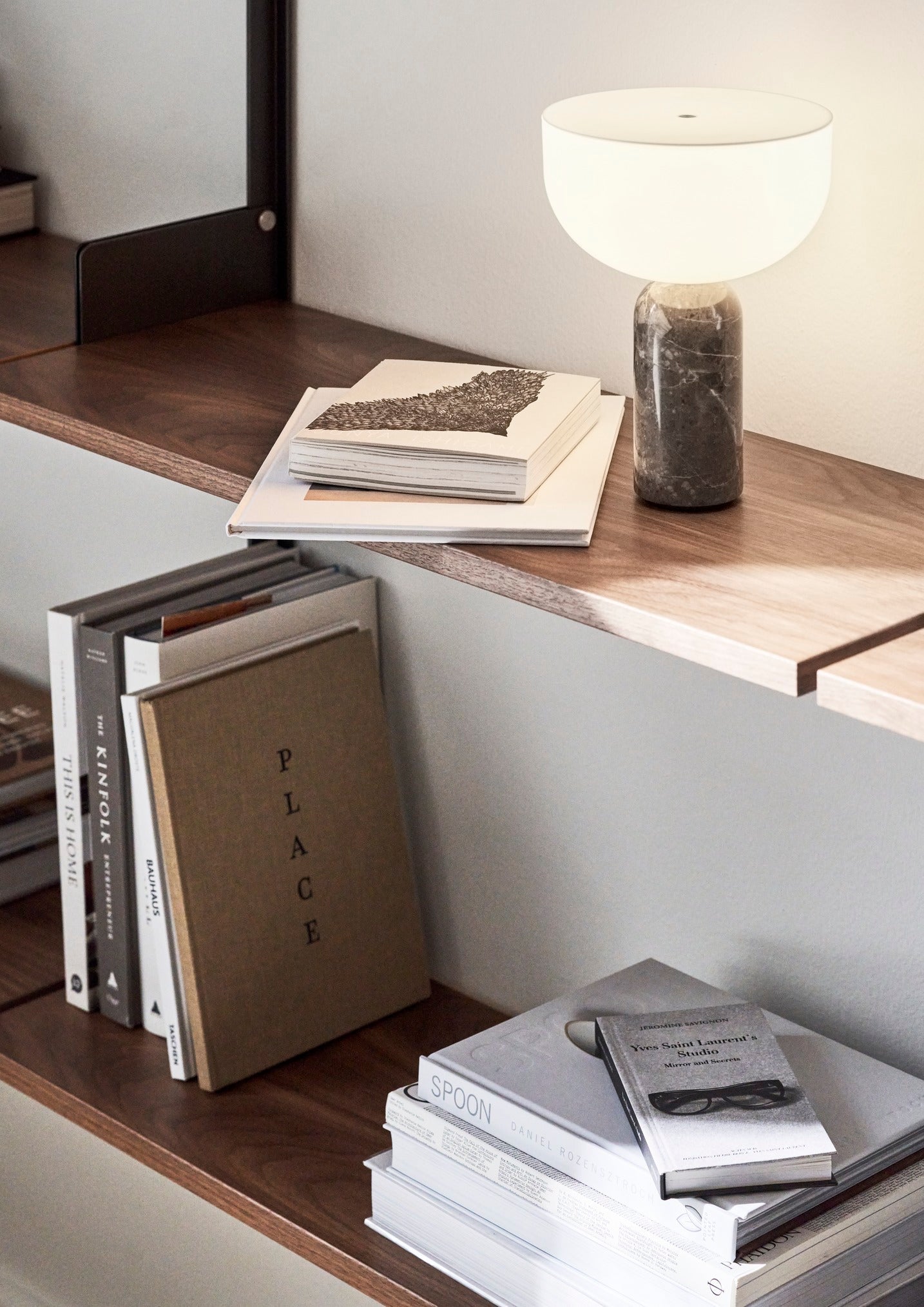 Kizu Portable Lamp Gris du Marais by New Works in wall shelving bookcase setting.