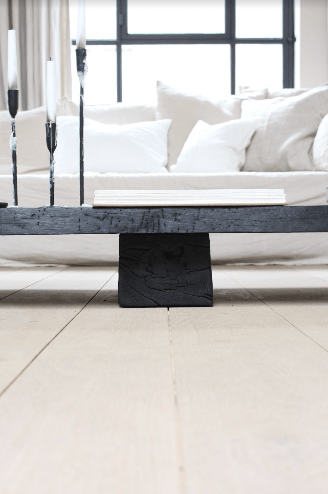 The Burned Black Coffee Table seen en profil in a light and neutral interior at Enter The Loft.