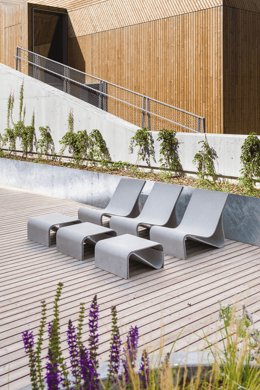 Three Sponeck Chairs with matching Side Tables by Julia von Sponeck set in a outdoor lounge deck area.