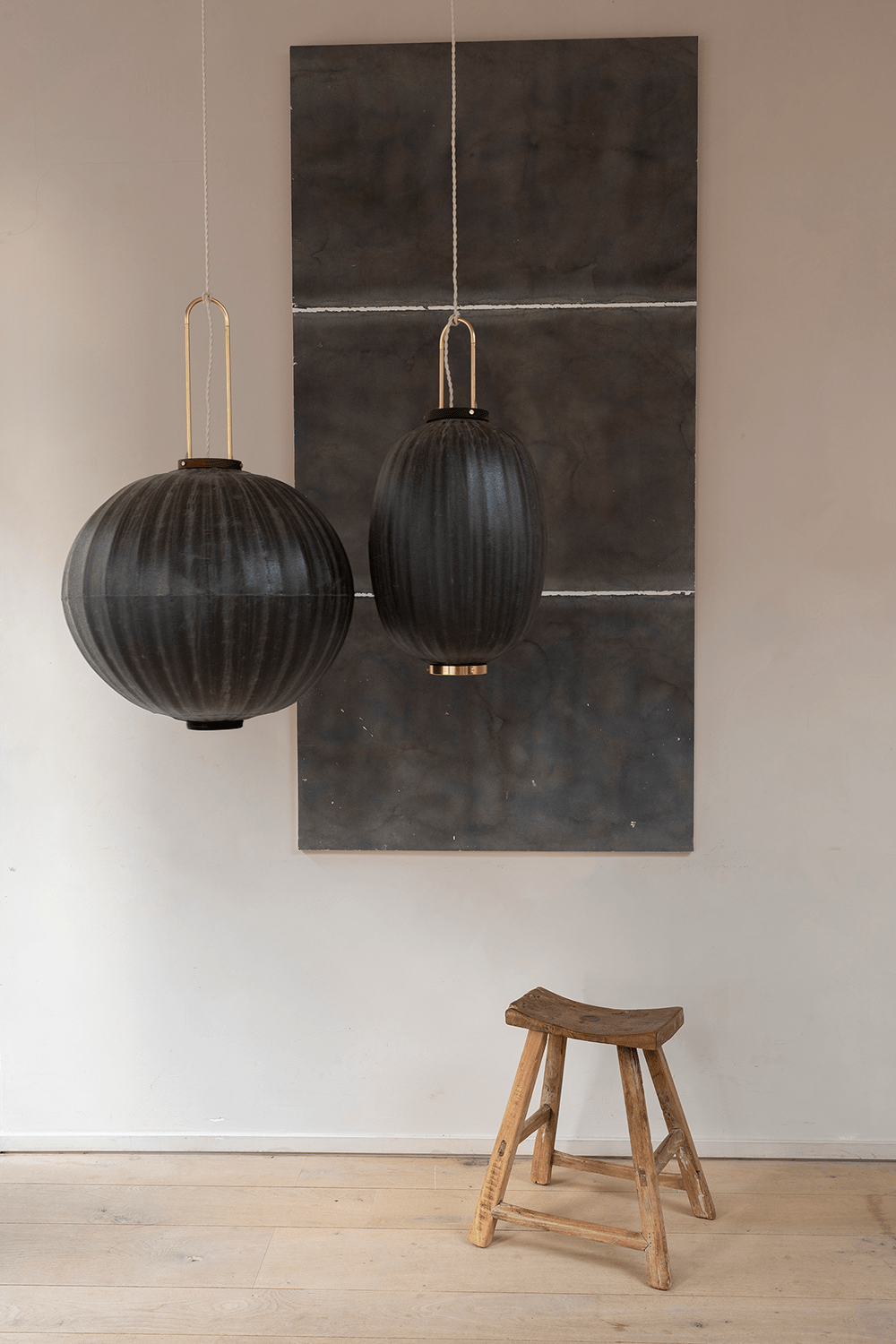 Mandarin shape and Oval shape Taiwan Lanterns hanging in front of a painting with a wooden stool.