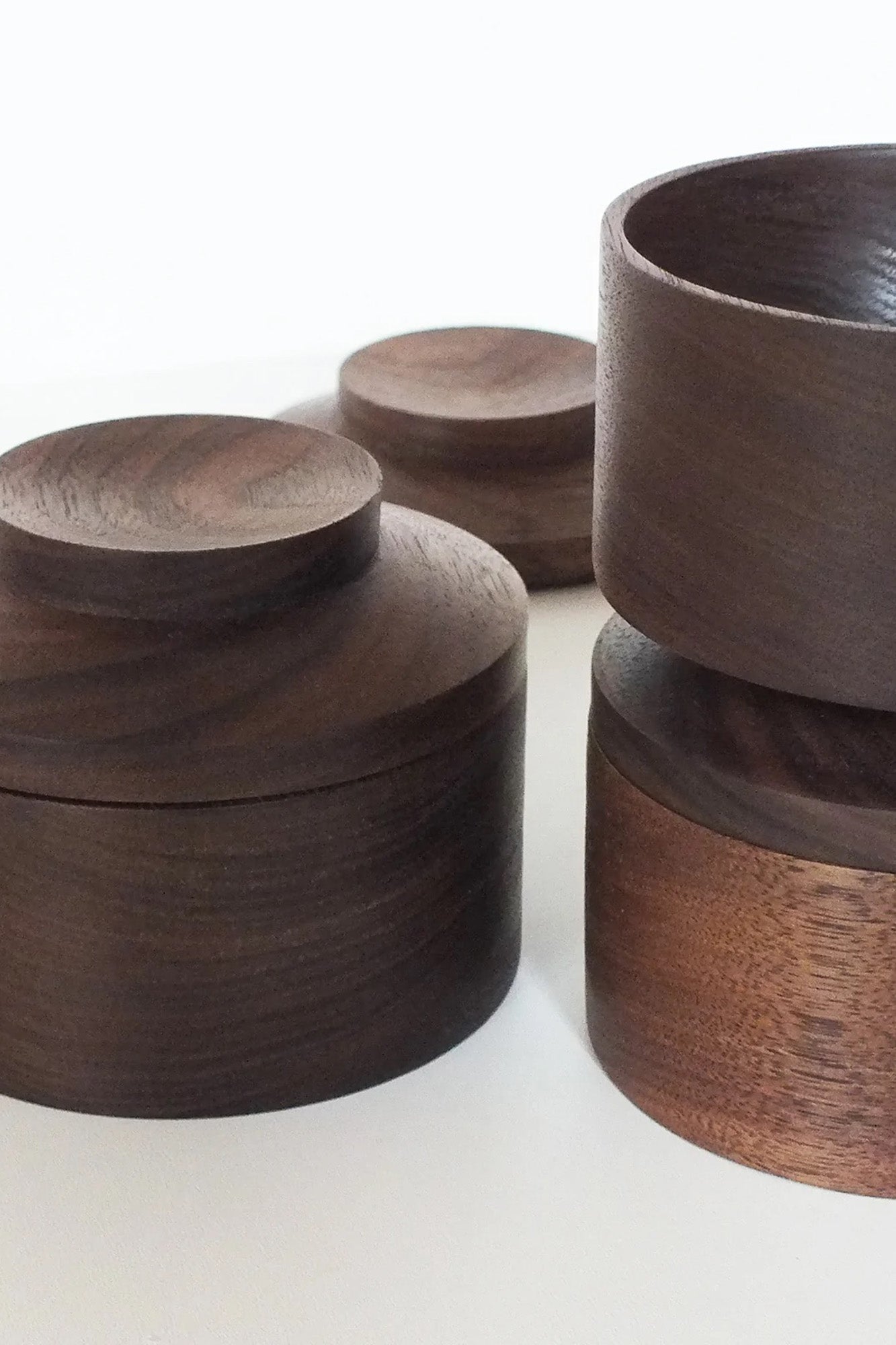 Close-up of the Repeat Stackable Little Storage Jars - The unique stackable design and dark walnut wood grains are highlighted in this close-up view.