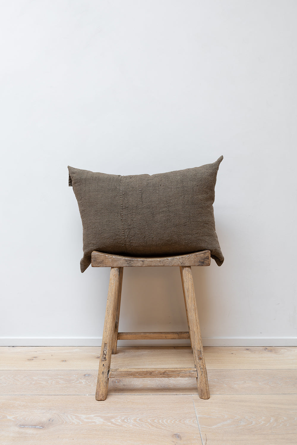 Chanvre Vintage - Bronze Cushion by Isabelle Yamamoto set on a Japanese wooden stool.